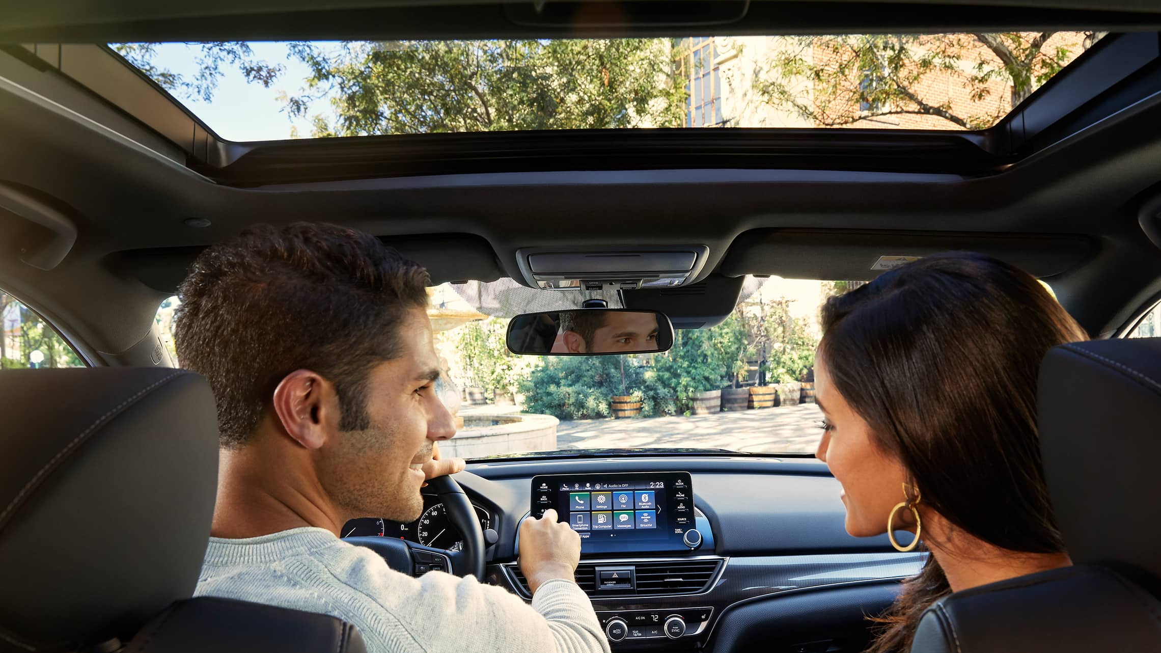 Vista interior desde los asientos traseros del detalle de la activación del techo corredizo con un toque que se muestra abierto en el Honda Accord Sport 2.0T 2021.