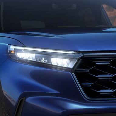 2027 Honda CR-V Sport Touring Hybrid in Canyon River Blue Metallic front close up of LED headlights (Compact Crossover SUV).